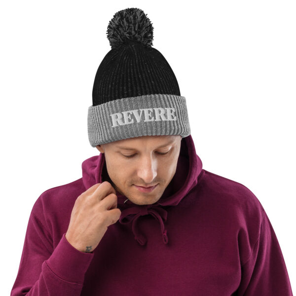 man wearing black and Grey pom pom hat with Revere embroidered graphic