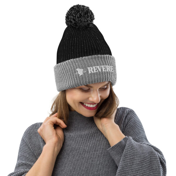 woman wearing a grey and black beanie with Revere 1801 graphic