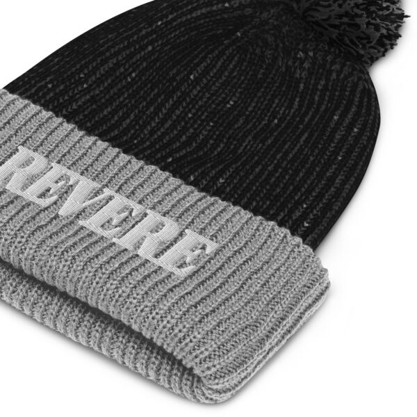 close up of black and Grey pom pom hat with Revere embroidered graphic