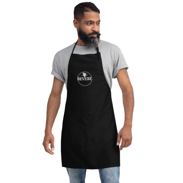 man with beard in black apron with white Revere logo